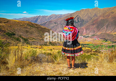 Indigenen Quechua Dame in traditioneller Kleidung (Rock, Hut und Textil) und Frisur im Heiligen Tal der Inka in der Nähe von Cusco, Peru. Stockfoto