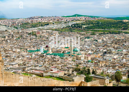 Stadtblick, Fes mit Stadtmauer, Universität Al Quaraouiyine, dahinter grüne Hügel, Fes, Marokko Stockfoto