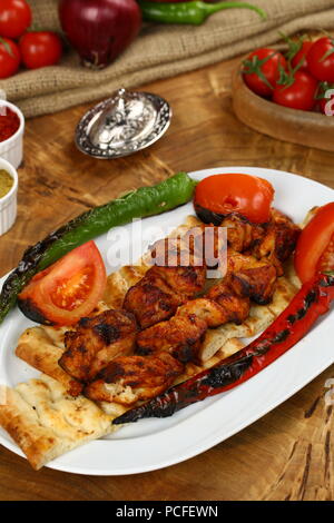 Spieße mit gegrilltem Huhn auf Platte mit garnieren Stockfoto