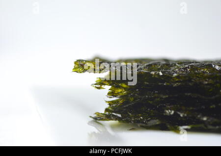 Blick von oben auf die getrockneter Seetang Detail: Nori. Auf weiß isoliert. Nährstoff reichen vegan, roh und gesunde Gemüse. Stockfoto