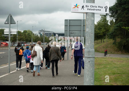 Glasgow, Schottland, Großbritannien. 02 August, 2018. Eine veranstaltung Freiwillige und Zuschauer, Wandern twoards der Sir Chris Hoy Velodrome (Emirates Arena) in der Gegend von Glasgow Dalmarnock vor der ersten Veranstaltungen der Glasgow 2018, a multi-Sport Events. Die meisten Sportarten wird bewirtet, in Schottland, mit dem Velodrom Hosting die Spur Radsport. Credit: Elizabeth Leyden/Alamy leben Nachrichten Stockfoto