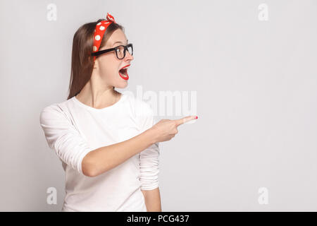 Frage mich, Gesicht und zeigen Porträt der Schönen emotionalen junge Frau im weißen T-Shirt mit Sommersprossen, schwarze Brille, rote Lippen und Kopfband. st Stockfoto