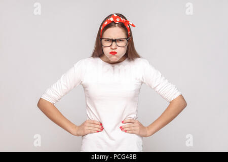 Wütend thinkful, hob die Hände. Porträt der Schönen emotionalen junge Frau im weißen T-Shirt mit Sommersprossen, schwarze Brille, rote Lippen und Kopfband. Pflege Stockfoto