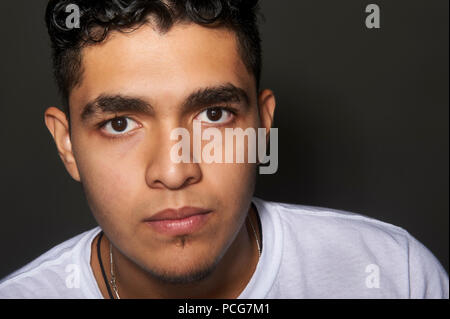 Studio Portrait eines 19 Jahre alten jungen Mann, trug ein weißes T-Shirt, mit Blick auf die Kamera Stockfoto