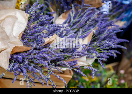 Lavendel Blumenstrauß in einem einfachen, raues Papier, realen Szene in den Blumenmarkt. Stockfoto