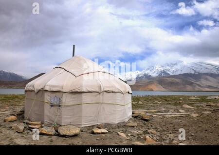 Die jurte vor Karakul See in der Uigurischen Autonomen Region Xinjiang China mit Muztagh Ata Hügel im Hintergrund. Stockfoto