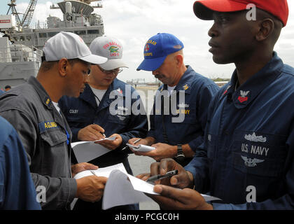 Matrosen an Bord der multipurpose Amphibious Assault ship USS Bataan Rettungsinsel Aufgaben während einer Übung zum Verlassen des Schiffes zu diskutieren. Bataan bereitet sich auf seinen ersten unterwegs in mehr als vier Monaten nach einer geplanten Wartung Verfügbarkeit bei BAE Systems Norfolk Schiff. Stockfoto