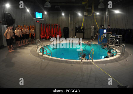 Die Studierenden bekommen einen Sicherheit Schriftsatz von Navy Taucher vor der Teilnahme am Submarine Escape trainer Evolution an die grundlegenden Eingetragen U-Schule an der Naval Submarine Base New London, Anschl. Stockfoto