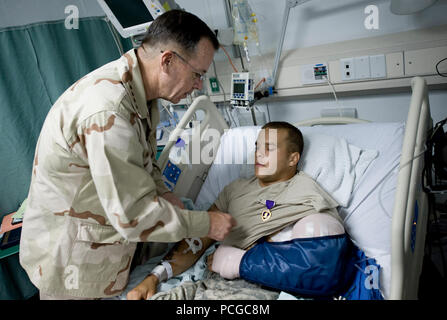 Vorsitzende des Generalstabs Marine Adm. Mike Mullen präsentiert eine Purple Heart-Medaille an Armee Sgt. Marcus Liebe auf Bagram Air Field, Afghanistan, 14. Juli 2009. Liebe, von Delta Firma, 1 Battalion, 87th Infantry Regiment, 3. Brigade Combat Team, 10 Mountain Division aus Fort Drum, N.Y., wurde die Medaille für eine Schussverletzung früh am Tag empfangen. ( Stockfoto