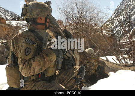 Ein Soldat der US-Armee sorgt für Sicherheit während einem Kampf resupply Mission in Barge Matal im nördlichen Kunar Tal März 10. Der afghanischen Luftwaffe arbeitete in Zusammenarbeit mit dem Ministerium des Innern und der Streitkräfte der Koalition zur Vollendung der Aufgabe mit zehn Flugzeuge über 9.000 Kilogramm von Waffen, Munition und Nahrung der afghanischen nationalen Polizei in der entfernten Pfosten, wie lebenswichtig der afghanischen Beamten aufgrund seiner Nähe zu Pakistan und Geschichte der aufständischen Aktivität gesehen stationiert zu liefern. Nach der Versorgung Drop-off, Kräfte geladen über 80 ANP für Ihre jeweiligen Wohnungen gebunden folgende Stockfoto