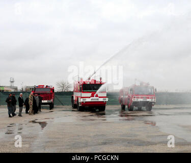 MAZAR-E-SHARIF, Afghanistan (Feb. 19, 2011) - Afghanische Feuerwehrmänner vom Flughafen Mazar-e Sharif die Fähigkeiten Ihrer neues Löschfahrzeug für die lokale Regierung demonstrieren, ANP und ISAF-Vertreter. Der Lkw war von der ISAF für die Verwendung durch die afghanische Regierung bei der Mazar-e Sharif Flughafen gespendet. Stockfoto