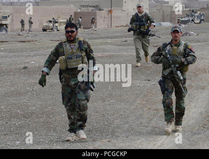 Afghan National Army Special forces Soldaten patrouillieren Zhargun Shar Dorf während einer Lichtung Bedienung Februar 21, 2014 aufständische Aktivität in Muhammad Agah Bezirk zu stören, Provinz Logar, Afghanistan. Zusammen mit afghanischen Polizei, fanden die Soldaten drei Sprengstoff und Waffen Caches, darunter etwa 100 Kilogramm Sprengstoff manipuliert zu explodieren. Stockfoto