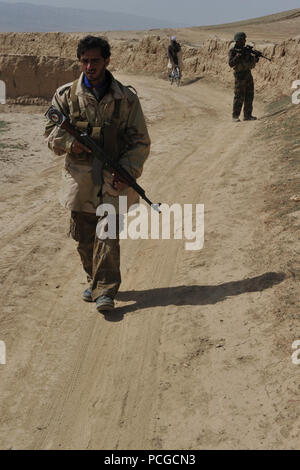 Die afghanische Polizei und der afghanischen Nation Army Special Forces Kommandos geben Sicherheit bei einer gemeinsamen ALP, NANSF und Koalition Special Operations Forces Patrouille in Latif Bezirk, Provinz Ghazni, Afghanistan, April 3. Sicherheitspatrouillen werden verwendet, um lokale Afghanen zu engagieren und die Sicherheit und Stabilität in ihrer Gemeinschaft zu bieten. Stockfoto