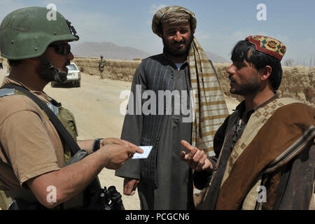 Ein Afghan National Army Special Forces Commando spricht mit zwei Dorfbewohner bei einer gemeinsamen afghanische Polizei, ANASF und Koalition Special Operations Forces Security Patrol, in einem kleinen Dorf in Murayni Bezirk, Provinz Ghazni, Afghanistan, April 3. Sicherheitspatrouillen werden verwendet, um lokale Afghanen zu engagieren und die Sicherheit und Stabilität in ihrer Gemeinschaft zu bieten. Stockfoto