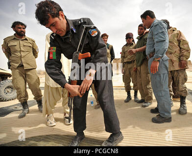 Der afghanischen nationalen Polizei Mitglieder verteilen AK-47 Gewehre an die afghanischen Polizei Rekruten während einem trockenen - Feuer Bereich Klasse in Nawbahar Bezirk, Zabul Province, Afghanistan, am 24. März. Die Klasse ist Teil eines 3-wöchigen Kurs lehrt, dass die ALP Kandidaten grundlegende Polizeiarbeit Verfahren, den Umgang mit Waffen und anderen notwendigen Fähigkeiten afghanische Bürger zu schützen und zu verteidigen. Stockfoto