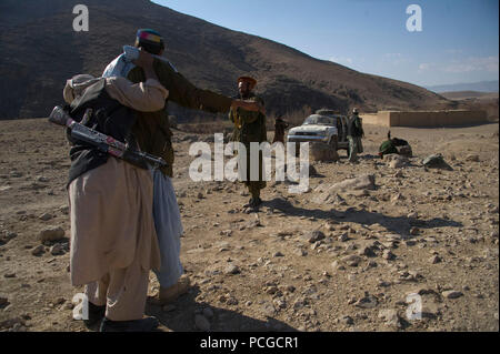 Afghanische Polizei Kandidaten Praxis checkpoint Suche Techniken während einer Klasse in Daykundi Kajran Bezirk, Provinz, Afghanistan, Jan. 8. Die Klasse ist Teil einer 3-wöchigen Schulung, dass die polizeiarbeit Verfahren umfasst, Waffen und anderen notwendigen Fertigkeiten zu schützen und die afghanischen Bürger verteidigen und die Stabilität in der Region. Stockfoto