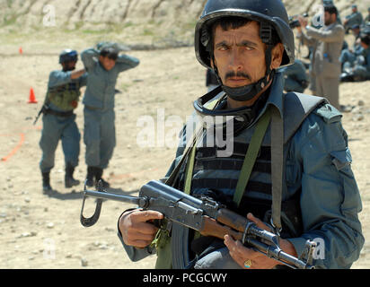 KABUL, Afghanistan (20. April 2010) - einer Afghanischen Nationalen zivilen Ordnung Polizei (Ancop), Non-Commissioned Officer, Recht, Uhren sein Sektor zugewiesen, während ein Teammitglied Verfahren unter einem Fahrer in Schutz bei traffic control point Ausbildung an einer Kabul. Mitglieder der Elite Polizei erhielt eine Ausbildung in der Flugsicherung und Kommunikation Gang, da sie für Operationen in Afghanistan vorbereiten. (US Navy Stockfoto