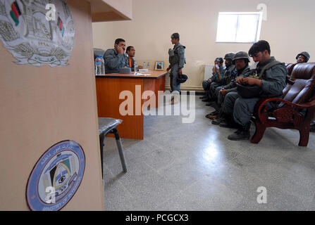 KABUL, Afghanistan (18 April 2010) - Afgahn Col. Khuda yar Toutakhil, Finance Officer, 4. Brigade Afghanischen zivilen Ordnung Polizei (Ancop), ganz links, Slips Mitglieder der Elite Force auf Arbeitsentgelt und Sozialleistungen zu einem Kabul. Die Polizeibeamten registriert und erhalten Einweisungen und Schulungen, da sie für Operationen in Afghanistan vorbereiten. (US Navy Stockfoto