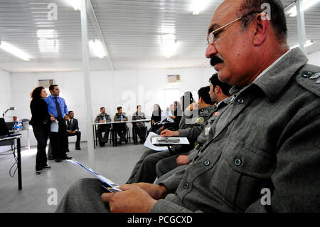 KABUL, Afghanistan (April 4, 2010) Eine der afghanischen nationalen Polizei (ANP) Offizier hört als Dolmetscher Teilnehmer Anweisungen vor der Durchführung Rollenspiel Szenarien bei inländischen und geschlechtsspezifische Gewalt Ausbildung an der Zentralen Training Center. ANP Dozenten und Forscher sind die Teilnahme an der Schulung, die auch bei der NATO Training Mission - Afghanistan gehalten wird. Die Ausbildung umfasst Diskussionen über die Rolle der Frauen und Stereotypen, die psychische Folgen von Gewalt, sekundäre Viktimisierung, was Opfer von der Polizei erwarten und sprechen mit Experten über Stockfoto