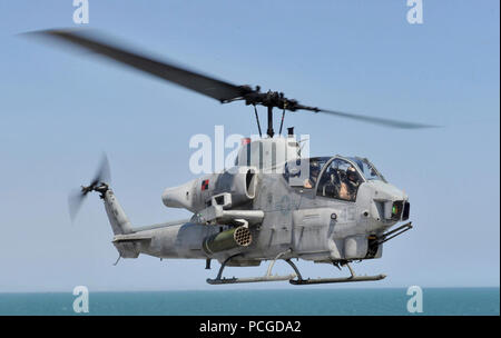 Ozean (10. April 2013) der Luftfahrt Bootsmann Mate 3. Klasse Joseph Grippo Züge eine unter Anweisung Flugzeuge Direktor von multipurpose Amphibious Assault ship USS Iwo Jima (LHD7) während der flugbetrieb an Bord der multipurpose Amphibious Assault ship USS Bataan (LL 5). Die AH-1W Super Cobra, die auf Marine Light-Helicopter Squadron (HMLA) 167 zugeordnet. Bataan ist unterwegs die Durchführung von Ausbildungsmaßnahmen und Qualifikationen. Stockfoto