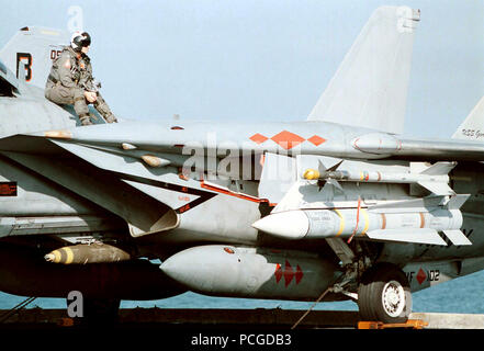 US Navy Lieutenant Steve Nevarez nimmt eine kurze Pause vom Stress des Flight Deck Operationen auf einer F-14B Tomcat Strike Fighter, Fighter Squadron eine Null Zwei (VF-102). Flugzeug ist bewaffnet mit einem AIM-9L Sidewinder kurze Reichweite, IR (Infrarot)-Rakete in die Luft; Ziel-54 C Phoenix long range Radar geführte, Luft-zu-Luft Raketen und eine Mk 82 500 lb. Bombe. Die Atomgetriebenen Flugzeugträger GEORGE WASHINGTON (CVN 73) und VF-102 sind derzeit die Durchführung von Operationen im Persischen Golf zur Unterstützung der UN-Sanktionen gegen den Irak. Operation SOUTHERN WATCH, 2. Dezember 1997. Stockfoto