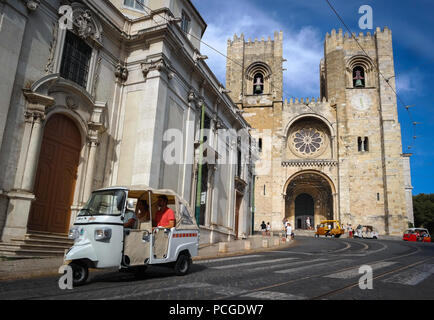 Lissabon. Touristen vermeiden der steile Aufstieg durch ein Tuk Tuk. Kathedrale Zé im Hintergrund. Stockfoto