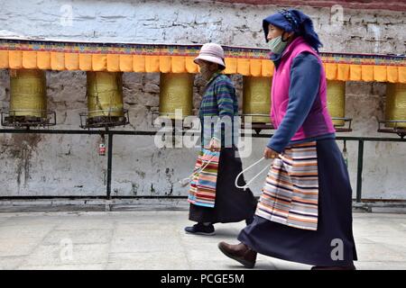 LHASA, Tibet autonomen Region, China - ca. Mai 2018: Zwei Frau entlang tibetische Gebetsmühlen. Stockfoto