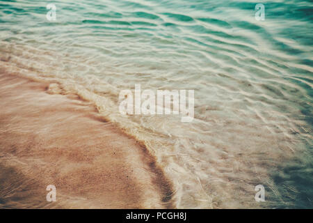 Nahaufnahme Makroaufnahme von Meer Ozean Green Blue Wave Wasser, Sandstrand Hintergrund mit Copyspace. Getönt mit Retro Vintage film Effekt Stil instagram Fil Stockfoto