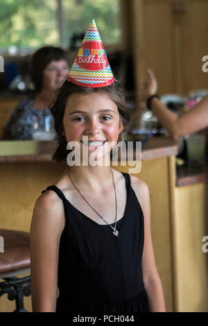 Lächelnd 8 yearr alt, tragen Geburtstag hat, in einem schwarzen Trägerkleid. Großes Lächeln zeigt Strebe und ein hübsches Gesicht/Model Release $ 104 Stockfoto