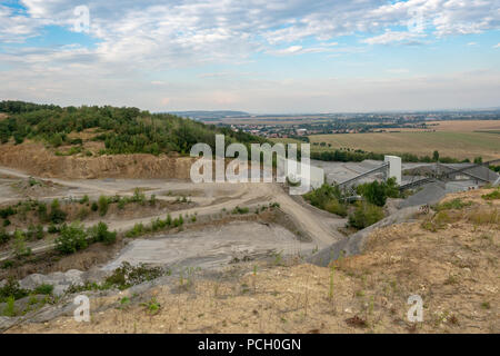 Bergbau in der granitsteinbruch. Gurtförderer und Bergbaumaschinen in einem Steinbruch. Steinbruch mit Silos, Förderbänder und Haufen von Steinen. Stockfoto