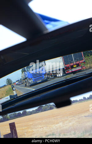 LKW auf zweispurigen Reisen spiegelt sich in Fahrzeug Rückspiegel uk Stockfoto