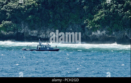 RITA, Guam (Feb. 14, 2014) ein Patrouillenboot der US Naval Base Guam Sicherheit überwacht die japanischen kommerziellen Fischereifahrzeug Daiki Maru in der Nähe der Spanischen Treppe Feb 14. Segler aus Hubschrauber Meer Combat Squadron (HSC) 25 führte eine Such- und Rettungsaktion und rettete 10 Fischer aus dem sinkenden Schiff gelaufene Oeltanker Feb 13 lief. Die Fischer wurden in U.S. Naval Hospital Guam zur Auswertung transportiert und später wieder freigelassen. Stockfoto