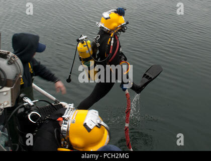 EVERETT, Washington (Jan. 23, 2013) Navy Diver 2. Klasse Adam Coe tritt das Wasser Reparaturen auf einem Pier am Naval Station Everett zu führen. Stockfoto