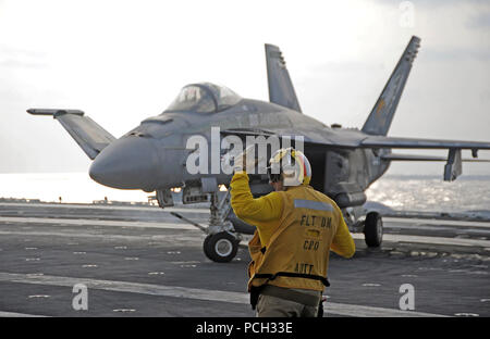 PHILIPPINENSEE (15. November 2012) Chief Aviation Boatswain Mate (Handling) Muhammad Morad aus Damaskus, Syrien, leitet eine F/A-18E Super Hornet aus der Adler des Strike Fighter Squadron (VFA) 115 auf dem Flugdeck der US Navy nach vorne bereitgestellt Flugzeugträger USS George Washington (CVN-73) im routinemäßigen Flugbetrieb. George Washington und seine eingeschifften Geschwader Carrier Air Wing (CVW) 5, bieten eine kampfbereit Kraft, die schützt und verteidigt das kollektive maritimen Interesse der USA und ihrer Verbündeten und Partner in der Region Asien-Pazifik. Der US-Marine wird ständig auf bereitgestellt. Stockfoto