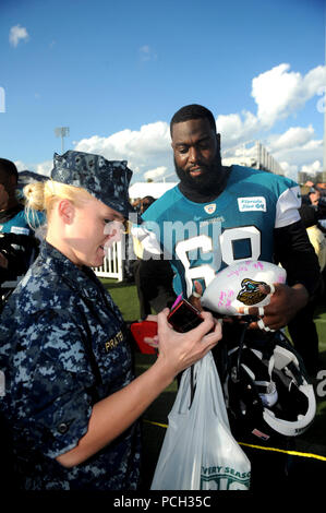 JACKSONVILLE, Florida (6. November 2012) Guy Whimper, beleidigender Gerät für den Jacksonville Jaguars, Schilder Sport-Erinnerungsstücke für Segler, die nach einer Jaguare Praxis. Mehr als 300 Matrosen und Marinesoldaten versammelten sich im Jaguare Praxis Stadion, die Spieler treffen sich im Rahmen der Stadt Jacksonville "Woche der Tapferkeit" und in Vorbereitung auf die kommende Navy Marine Corps Classic. Das Spiel ehrt Veteranen, aktive und reserve Soldat innen und Soldaten und deren Angehörige. Amerikas Auswärtsteam, Navy und Marine Corps sind zuverlässig, flexibel und bereit, zu antworten, oben und unten das Meer als auch als weltweit Stockfoto