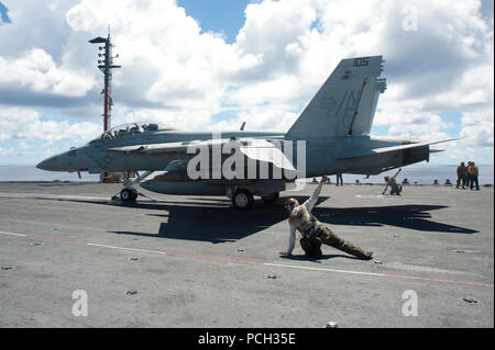 Pazifik (Sept. 3, 2012) schützen die Diamantmarkierungen von Strike Fighter Squadron (VFA) 102 zugewiesen geben das Signal zu einer F/A-18E Super Hornet aus dem Flight Deck der Flugzeugträger USS George Washington (CVN 73) Bei Flugbetrieb starten. Stockfoto