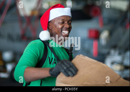 Arabischen Golf (31. 20, 2013) Fachkraft für Lagerlogistik 3. Klasse Antony Muiruri, von Las Vegas, zugeordnet zu den Seahawks von Airborne Early Warning Squadron (VAW) 126, verarbeitet die Pakete in den Hangar Bucht der Flugzeugträger USS Harry S. Truman (CVN 75) während einer Auffüllung-auf-See. Harry S. Truman, Flaggschiff der Harry S. Truman Carrier Strike Group, ist in den USA der 5. Flotte Verantwortungsbereich Durchführung Maritime Security Operations eingesetzt, die Unterstützung von Theater Sicherheit Bemühungen um Zusammenarbeit und Unterstützung der Operation Enduring Freedom. Stockfoto