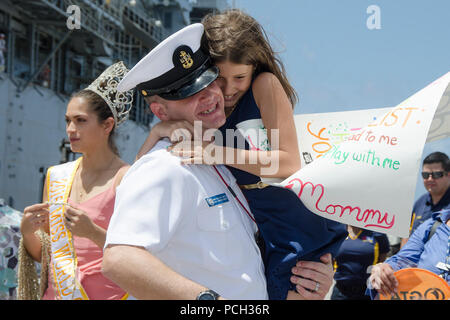 POLARIS, Guam (11. April 2016) - ein Seemann, der zum U-Boot Tender USS Emory S. Land zugewiesen (39) schmiegt sich an seine Tochter, nachdem das Schiff von der Bereitstellung zurück, April 11. Die Rückkehr nach Guam ist Emory S. Land der Erste, da der Wechsel von homeport von Diego Garcia zu Guam Dez. 23. Emory S. Land ist ein EXPEDITIONARY U-Boot Ausschreibung Durchführung von koordinierten neigten, Liegeplätze und flott Wartung in den USA 5. und 7 Flotte Bereiche. Stockfoto