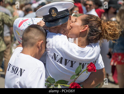 SAN DIEGO (7. Mai 2018) Chef der Luftfahrt Bootsmann Mate (Kraftstoff) Miguel Mosquera, der nimitz-Klasse Flugzeugträger USS Theodore Roosevelt (CVN 71), drückt seine Familie nach der Rückkehr von einer geplanten Einsatz. Theodore Roosevelt zog San Diego, Okt. 6, 2017 und die Bereitstellung von unterstützenden Maßnahmen innewohnenden Lösen und der Freiheit des Sentinel, sowie Sicherheit im Seeverkehr Bemühungen um Zusammenarbeit im 5. und 7. US-Flotte Bereiche des Betriebes verbracht. Stockfoto