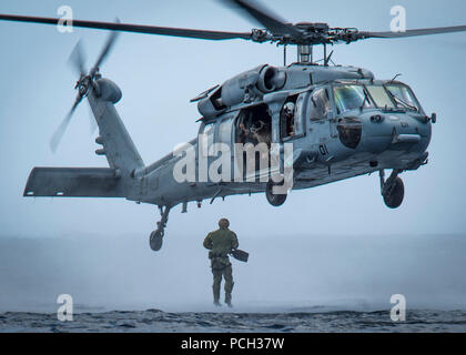 GUAM (8. Mai 2017) ein Seemann, der auf die Beseitigung von Explosivstoffen Mobile Einheit (EODMU) 5 springt von einem MH-60 Sea Hawk Hubschrauber vor der Küste von Guam auf der "Insel der Ritter" Hubschrauber Meer Combat Squadron (HSC) 25 zugewiesen. EODMU-5 testet seine Fähigkeit, Vermögenswerte aus verschiedenen Plattformen, einschließlich Hubschrauber und Patrouillen, die adaptive Interoperabilität zu erhöhen. Stockfoto