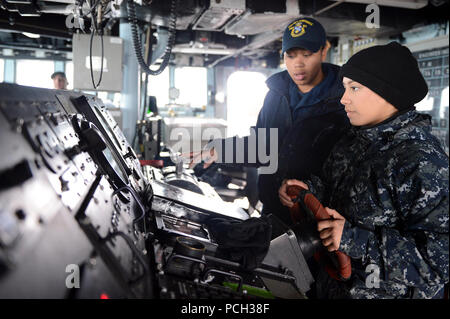 In den Gewässern WESTLICH VON DER KOREANISCHEN HALBINSEL (18. März 2013) Bootsmann Mate 3. Klasse Bretagne Chiles Züge Seaman Jessica Canas, während Sie bemannt das Ruder an Bord der Arleigh-Burke-Klasse geführte Anti-raketen-Zerstörer USS McCampbell (DDG85). McCampbell ist Teil der Destroyer Squadron 15, Yokosuka, Japan bereitgestellt und ist unterwegs die bilateralen Übung Fohlen Eagle zu führen 2013 mit befreundeten Nation, Republik Korea zur Unterstützung der regionalen Sicherheit und Stabilität der Indo-Asia-Pazifik-Region. Stockfoto