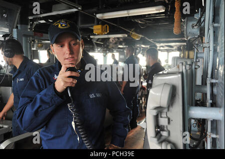 Philippinischen MEER (Nov. 4, 2012) Bootsmann Mate 3. Klasse Ashley Norman, der Arleigh-burke-Klasse geführte Anti-raketen-Zerstörer USS McCampbell (DDG85), übergibt eine Nachricht für die Besatzung des Schiffes 1 MC im Pilot House. McCampbell ist Teil der George Washington Carrier Strike Group, die US-Marine ist nur kontinuierlich vorwärts - eingesetzt Carrier strike Group, Yokosuka, Japan, und führt zur Zeit eine Routine Western Pacific Patrol zur Unterstützung der regionalen Sicherheit und Stabilität in der asiatisch-pazifischen Region von entscheidender Bedeutung. Stockfoto