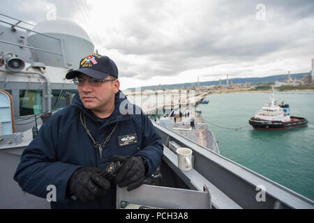 AUGUSTA BAY, Italien (31. 11, 2014) Chief Master-at-Arms Joseph Datka, aus Oconomowoc, Wis., überwacht die zivile Schlepper als geführte Anti-raketen-Zerstörer USS Cole (DDG67) fährt Augusta Bay nach einem Hafen besuchen. Cole, homeported in Norfolk ist die Durchführung von naval Operations in den USA 6 Flotte der Verantwortung für die nationale Sicherheit der USA Interessen in Europa. Stockfoto