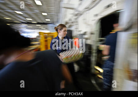 Ozean (22 Juli 2012) Intelligence Specialist 2. Klasse Loni Dillon bewegt sich Fälle von Soda während einer Auffüllung auf See an Bord der Flugzeugträger USS Nimitz (CVN 68) Während der Rand der Pazifischen (Rimpac) 2012 Übung. Zwanzig - zwei Nationen, mehr als 40 Schiffe und u-Boote, mehr als 200 Flugzeugen und 25.000 Mitarbeiter sind die Teilnahme an der Übung RIMPAC vom 29. Juni bis 3. August, in und um die Inseln von Hawaii. Die worldХs größte internationale maritime Übung RIMPAC bietet eine einzigartige Gelegenheit, dass Training hilft den Teilnehmern fördern und unterstützen die kooperativen Beziehungen, sind Stockfoto