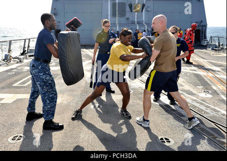 US-5TH Flotte Zuständigkeitsbereich (23. Januar 2013) Yeoman 1. Klasse Charma Smalls, Center, Praktiken Flügelschlagfrequenz Taktik des Kanoniers 3. Klasse Dinobadele Mandley, links, Mate und Chief Fire Controlman James Daniels nach besprüht mit Oleoresin Capsicum während Sicherheit Reaktion zwingen, Ausbildung an Bord der geführte Flugkörper-Zerstörer USS Jason Dunham (DDG-109). Jason Dunham mit John C. Stennis Strike Group in den USA bereitgestellt wird 5. Flotte Aufgabengebiet Durchführung von maritimer Sicherheitsoperationen, Theater Sicherheitsbemühungen Zusammenarbeit und Unterstützung Missionen für die Operation Enduring Freedom Stockfoto