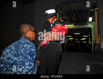 SASEBO, Japan (31. 3, 2012) in der 2. Klasse Mineman Damond Daley schlägt seine Freundin kulinarische Specialist 2. Klasse Andrenel Frazier nach einem dreimonatigen Einsatz an Bord der Amphibisches Schiff USS BONHOMME RICHARD (LHD6). Bonhomme Richard ist der Leitung Schiff der nur Vorwärts - bereitgestellt Amphibious ready Gruppe und arbeitet in den USA 7 Flotte Verantwortungsbereich. Stockfoto