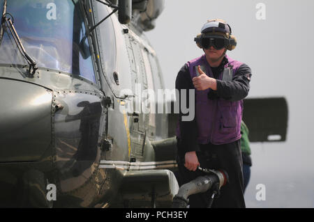 Meer (14. März 2013) Engineman 2. Klasse David Kirchens Signale in Vorbereitung der SH-60F Sea Hawk Hubschrauber zum Tanken an Bord des US-amerikanischen 7 Flotte Flaggschiff USS Blue Ridge (LCC 19). Stockfoto