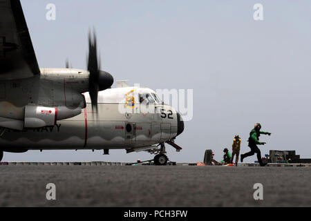 Meer (Juli 21, 2012) ein Matrose läuft auf Sicherheit nach einem C-2A Greyhound, die rawhides von Fleet Logistics Support Squadron (VRC) 40 in Position auf die während der flugbetrieb Katapult an Bord der Flugzeugträger USS Enterprise (CVN 65) gesperrt ist. Enterprise ist in die USA 5 Flotte Verantwortungsbereich Durchführung Maritime Security Operations eingesetzt, Theater Sicherheit Bemühungen um Zusammenarbeit und Unterstützung von Missionen im Rahmen der Operation Enduring Freedom. Stockfoto