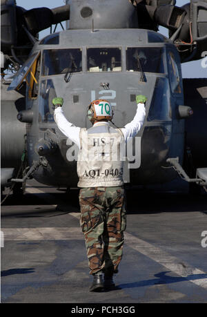 Persischen Golf (31. 13, 2007) ein Matrose, zugeordnet zu den "Dusty Hunde" der Helikopter Anti-submarine Squadron (HS) 7, Signale für die Piloten von einem MH-53E Sea Dragon, angeschlossen an die "BLACKHAWKS" der Hubschrauber Mine-Countermeasures Squadron (HM) 15, auf dem Flugdeck ruhig zu halten an Bord der Nimitz-Klasse Atom-Flugzeugträger USS Harry S. Truman (CVN 75). Truman und schiffte sich Carrier Air Wing (Cvw) 3 sind unterwegs auf einem planmäßigen Einsatz zur Unterstuetzung der Maritime Security Operations. U.S. Navy Stockfoto