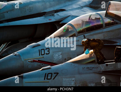 Arabischen Golf (31. 3, 2011) ein Seemann, Tücher, eine F/A-18F Super Hornet mit dem Schwarzen Aces zugeordnet von Strike Fighter Squadron (VFA) 41 an Bord der Nimitz-Klasse Flugzeugträger USS John C Stennis (CVN 74). John C Stennis ist in die USA 5 Flotte der Verantwortung die Durchführung der maritimen Sicherheit Betrieb und Support Missionen als Teil der Operationen Enduring Freedom und New Dawn eingesetzt. Stockfoto
